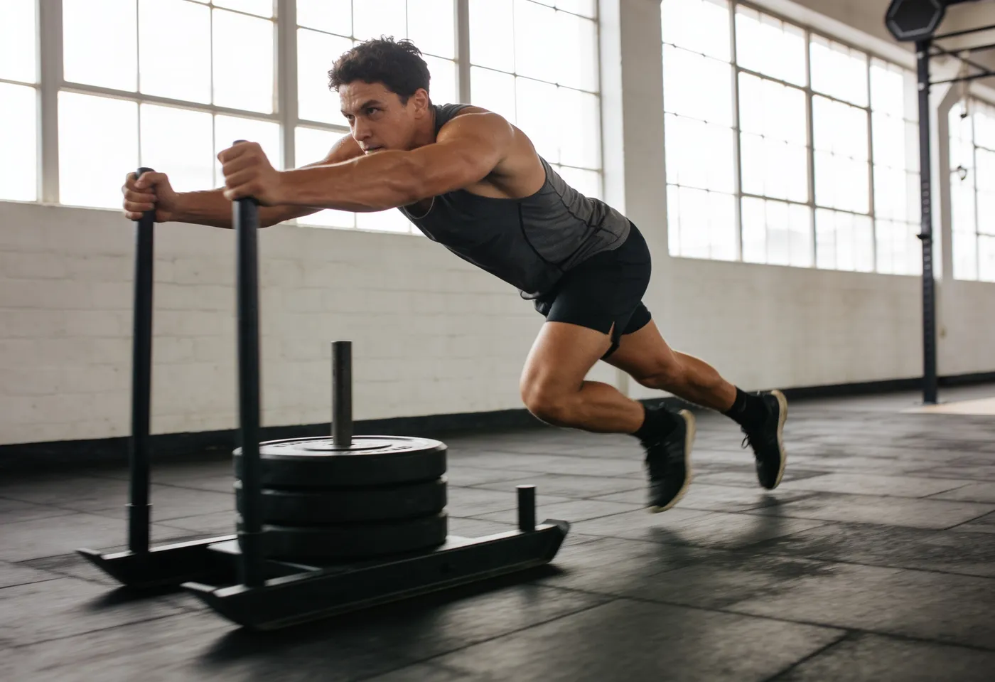 Athlete executing a fast, flawless sled push with flat-back drive posture